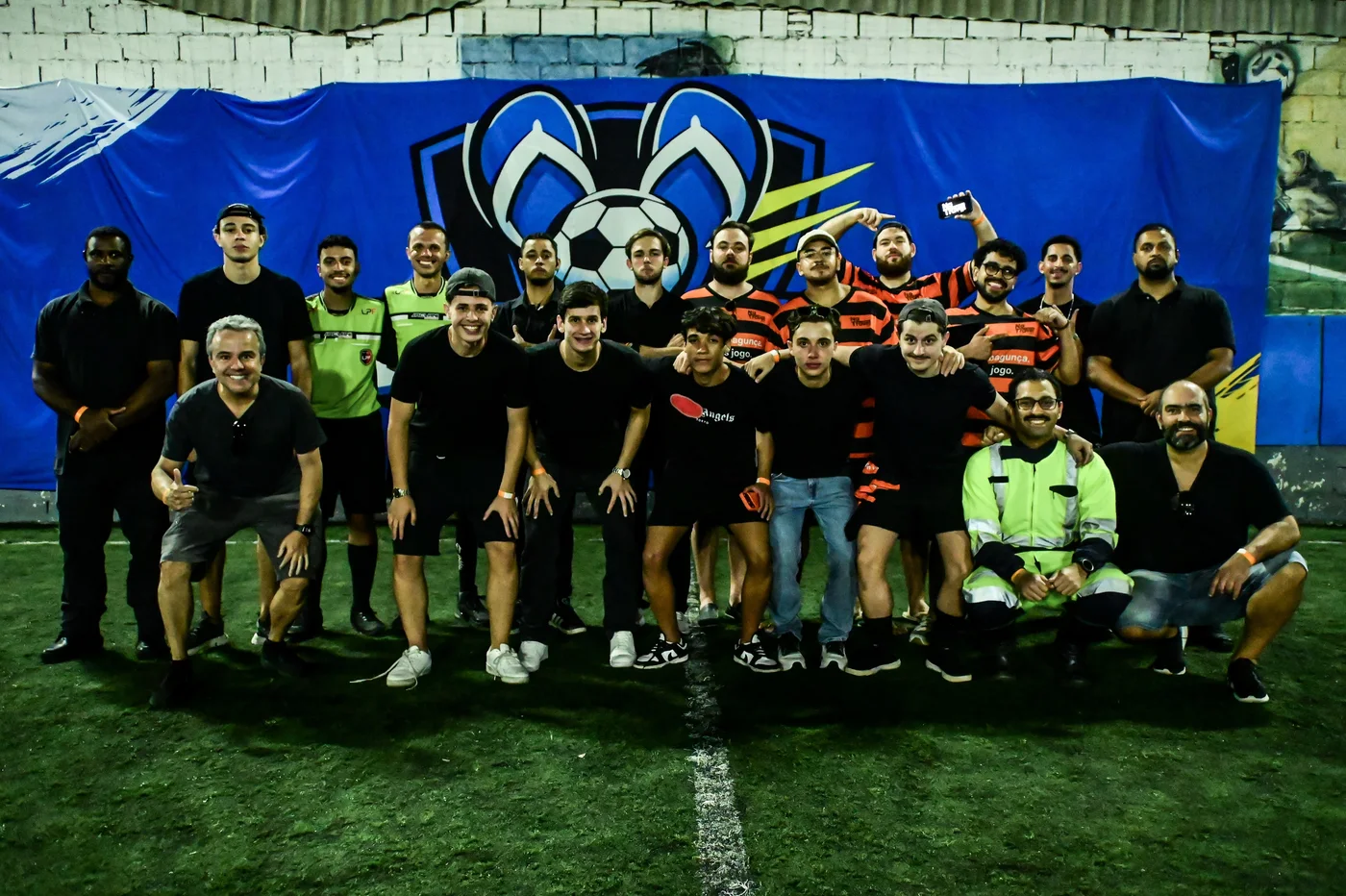 Participantes e integrantes do NaTrave! reunidos para uma foto diante da faixa da Chinelada Cup